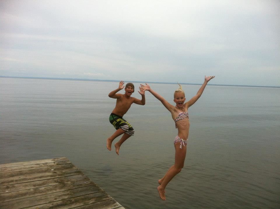 Katie's son and daughter jump off a dock and into a lake
